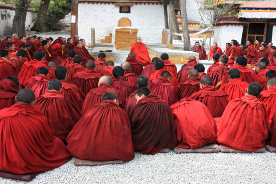 Mediterende monniken bij hun grote leider op de binnenplaats van het Sera klooster-1210